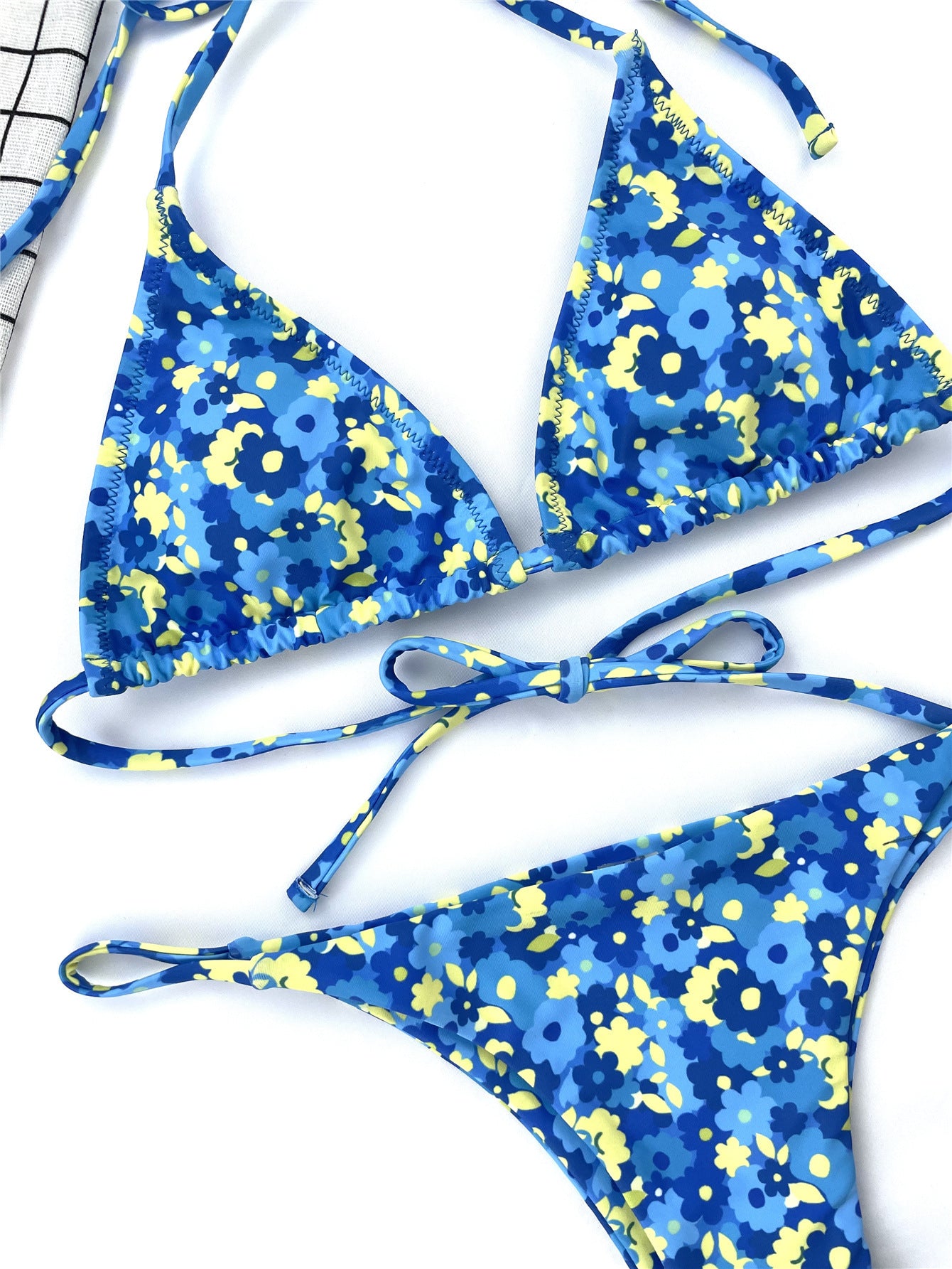 Conjunto de bikini con tiras laterales anudadas y cuello halter con estampado de plumas azules